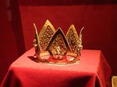 a gold crown sitting on top of a red cloth