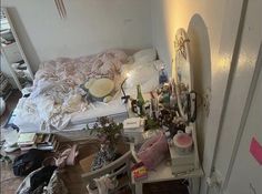 a messy bedroom with lots of clutter on the floor and in front of a mirror