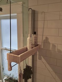 a bathroom with tiled walls and flooring, including a wooden shelf that holds various items