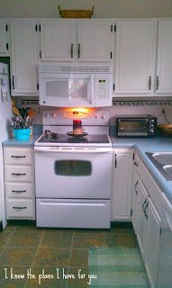 a white stove top oven sitting inside of a kitchen next to a refrigerator freezer