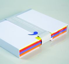 a white box with four different colored papers in it