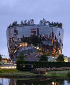 the reflection of an office building is seen in the mirror surface of the building's facade