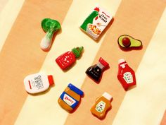 several different types of plastic food on a tablecloth with a striped cloth in the background