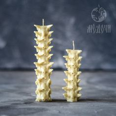 two candles are stacked on top of each other with spikes sticking out of the sides