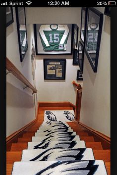 the hallway is decorated with pictures and rugs in black and white colors, along with framed football memorabilia