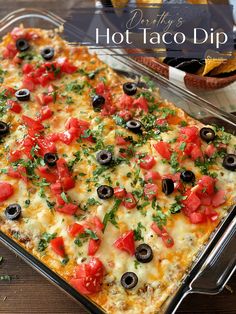 an enchilada casserole with tomatoes, black olives and cilantro