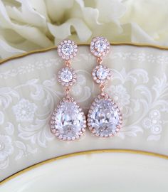 "Swarovski Pure Brilliance Cubic Zirconia rose gold bridal earrings feature pave framed rounds which dangle into a brilliant pear-shaped drop. These beautiful earrings are created in genuine Rose Gold plating and they're sure to look glamorous on brides looking for blush gold jewelry to accessorize their wedding gowns. Earrings measure 1-7/8\" Matching necklace: https://www.etsy.com/listing/273127374/bridal-backdrop-necklace-rose-gold-back?ref=shop_home_active_1 Matching bracelet: https://www.et Wedding Bridal Earrings In Rose Gold With Halo Design, Rose Gold Halo Bridal Earrings For Wedding, Rose Gold Bridal Drop Earrings With Elegant Design, Glamorous Rose Gold Dangle Bridal Earrings, Dazzling Rose Gold Wedding Earrings, Dazzling Rose Gold Earrings For Wedding, Dazzling Rose Gold Bridal Earrings, Rose Gold Drop Bridal Earrings For Formal Occasions, Rose Gold Teardrop Halo Jewelry