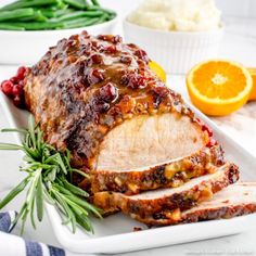 meatloaf with cranberry sauce and orange slices on a white platter