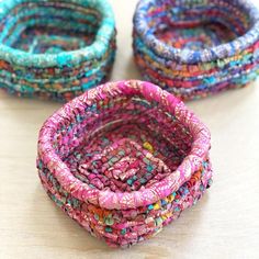 three different colored baskets sitting on top of a wooden table next to each other with beads in them