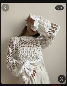 a woman is wearing a white crochet top and holding her hands on her head