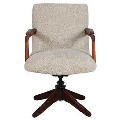 an office chair with a wooden armrest and white sheepskin upholstered seat