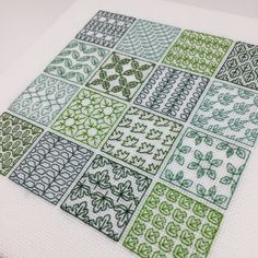 a cross stitch pattern with green and white squares