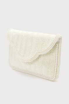 Make your big day look truly unique with an extra special accessory like the Lulus Immaculate Radiance White Pearl Beaded Clutch! The front of this stunning bag is adorned with an array of shiny beaded details and trimmed with gleaming faux pearls along the perimeter of the rectangular silhouette and scalloped front flap. Lift the hidden magnetic closure to reveal a lined interior with a sidewall pocket and plenty of room for all your bridal necessities! Detachable silver chain strap included. Lined. Clutch measures 10. 5" wide, 7" tall, and strap has 20. 5" drop. 100% Cottton. Spot Clean Only. Imported. Lulus | Immaculate Radiance White Pearl Beaded Clutch. Chic Embellished Pearl Bag, Glamorous White Embellished Clutch, Festive Clutch With Pearl Handle, Cream Beaded Clutch For Party, Cream Beaded Party Clutch, Chic Beaded Wedding Clutch, Glamorous Bags With Pearl Embroidery For Reception, Elegant Evening Bag With Pearl Handle For Festive Occasions, Glamorous Festive Bags With Pearl Embroidery