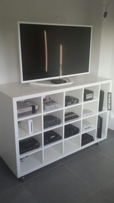 a flat screen tv sitting on top of a white entertainment center next to a wall