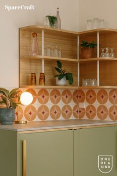 a kitchen counter topped with green cabinets and plants