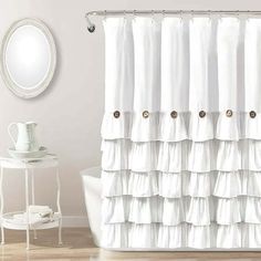 a white shower curtain with ruffles on the bottom and gold buttons at the bottom