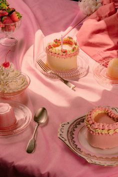 a table topped with cakes and desserts covered in frosting on top of plates