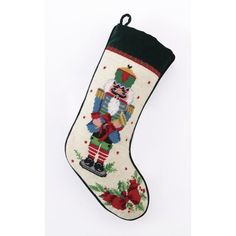 an embroidered christmas stocking with a nutcracker and holly wreath on the bottom