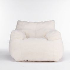 a white chair that is made out of sheepskin and has a pillow on it