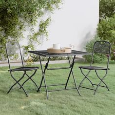 a table and two chairs sitting in the grass