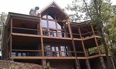 a large wooden house sitting on top of a hill