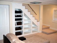 a living room filled with furniture and a staircase leading up to the second floor,