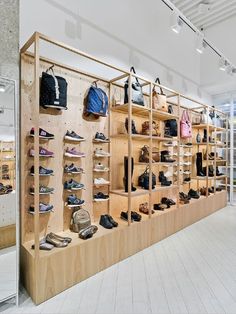 the inside of a shoe store with wooden shelves and shoes on display behind glass doors