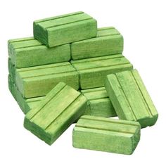 a pile of green wooden blocks sitting next to each other on top of a white surface