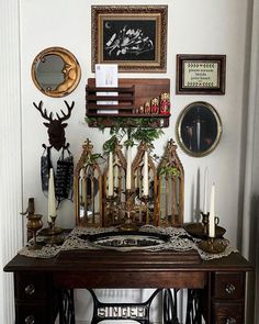 an old sewing machine sits on top of a table in front of pictures and candles