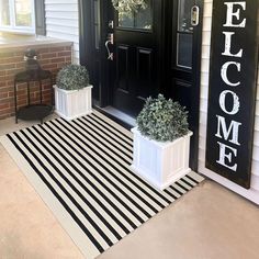 two planters on the front porch with welcome signs above them and a welcome mat