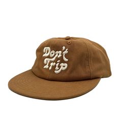 On a white background is a brown unstructured 6 panel baseball hat with white embroidery that reads, Don't Trip. Retro Short Brim Travel Hat, Retro Short Brim Hat For Travel, Summer Everyday Snapback Hat With Curved Brim, Vintage Adjustable Canvas Hat, Adjustable Vintage Canvas Hat, Cotton Snapback Hat For Beach, One Size, Retro Brown Cotton Baseball Cap, Vintage Brown Cotton Baseball Cap, Adjustable Canvas Travel Hat