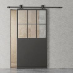 an empty room with a gray door and glass windows