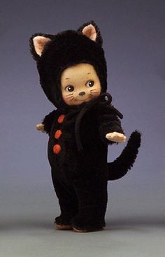 a small black cat doll standing on its hind legs