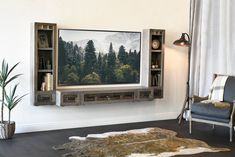 a living room with a large television mounted to the wall and shelves on the wall