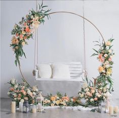 an outdoor swing decorated with flowers and greenery for a wedding or ceremony decoration in orange, yellow and white colors