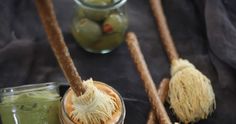 two jars filled with green liquid and some wooden spoons next to each other on a table