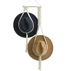 two hats hanging on a wall with one hat and the other is a tassel