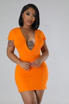 a woman in an orange dress posing for the camera with her hands on her hips