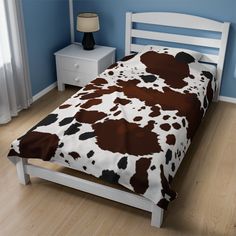 a bed with a brown and white cow print comforter