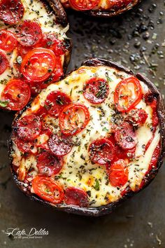 two pizzas sitting on top of a pan covered in cheese and tomatoes next to each other