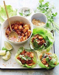 lettuce wraps filled with meat and vegetables on a tray next to dipping sauce