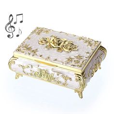 a white and gold music box with musical notes