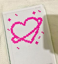 a cross stitch heart is shown on a notebook with crochet stitches in the shape of a heart