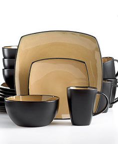 black and gold dishes are stacked on top of each other, with cups in the middle