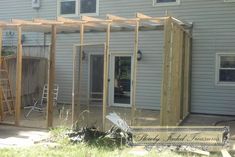 a house that is being built with some wood on the outside and in front of it