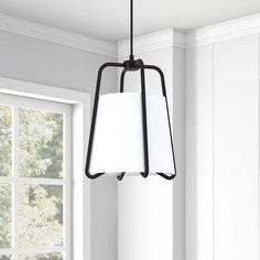 a light fixture hanging from the ceiling in a room with white walls and wood flooring