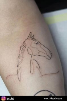 a tattoo on the leg of a woman with a horse drawn on it's side