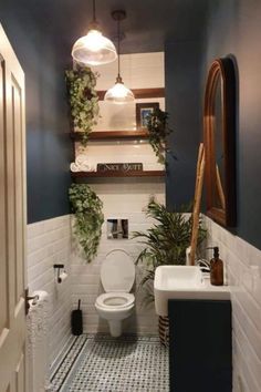 a bathroom with blue walls and white tile flooring, potted plants on the wall