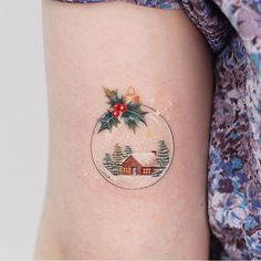 a small christmas ornament on the back of a woman's arm,