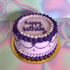 a purple and white birthday cake with the words happy birthday written on it's side